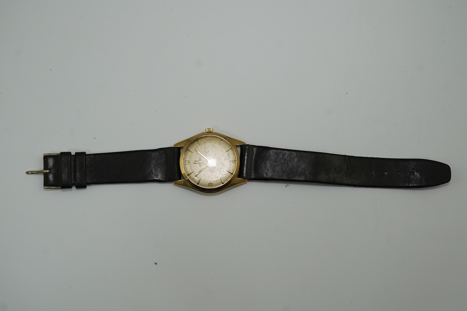 A gentleman's 1950's 9ct gold Omega manual wind wrist watch, with baton and Arabic numerals, movement c.420, case diameter 34mm, on associated leather strap. Condition- poor to fair